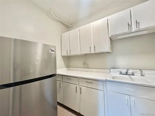 a kitchen with a sink a refrigerator and cabinets
