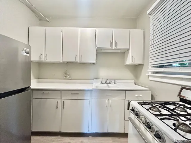 a kitchen with stainless steel appliances granite countertop a sink stove and cabinets