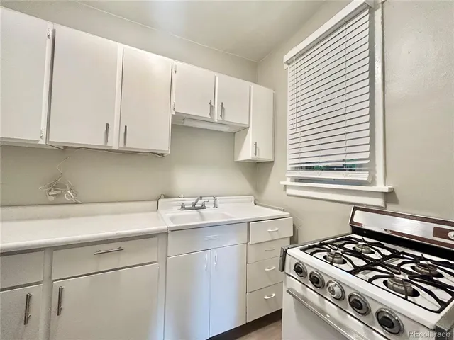 a kitchen with a sink stove and cabinets