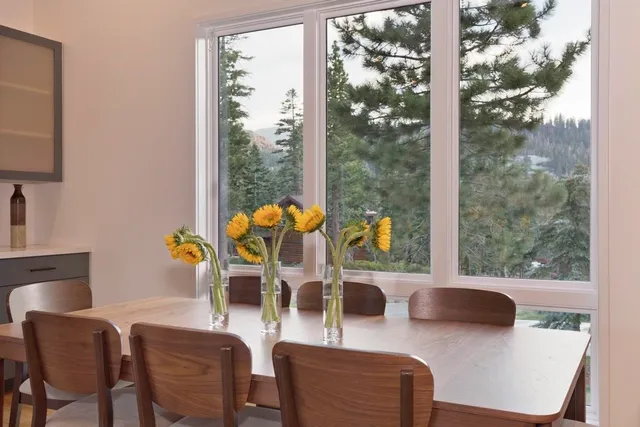 a dining room with furniture a large window and a chandelier