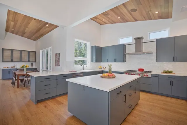 a kitchen with a sink a stove a dining table and chairs