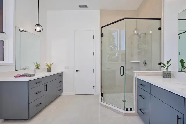 a bathroom with a double vanity sink mirror and shower