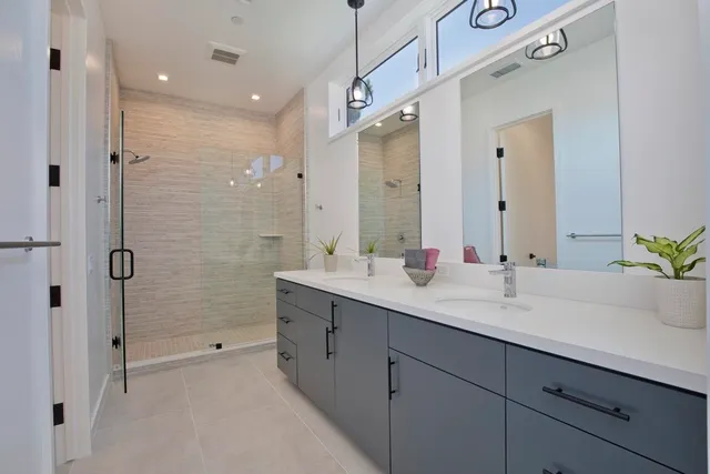 a spacious bathroom with a shower sink and mirror
