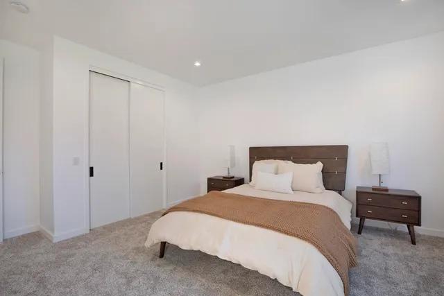 a bedroom with a bed and a night stand