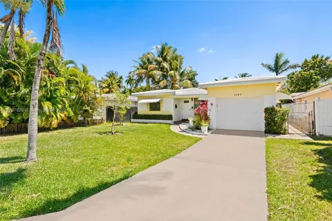 a front view of a house with a garden and yard