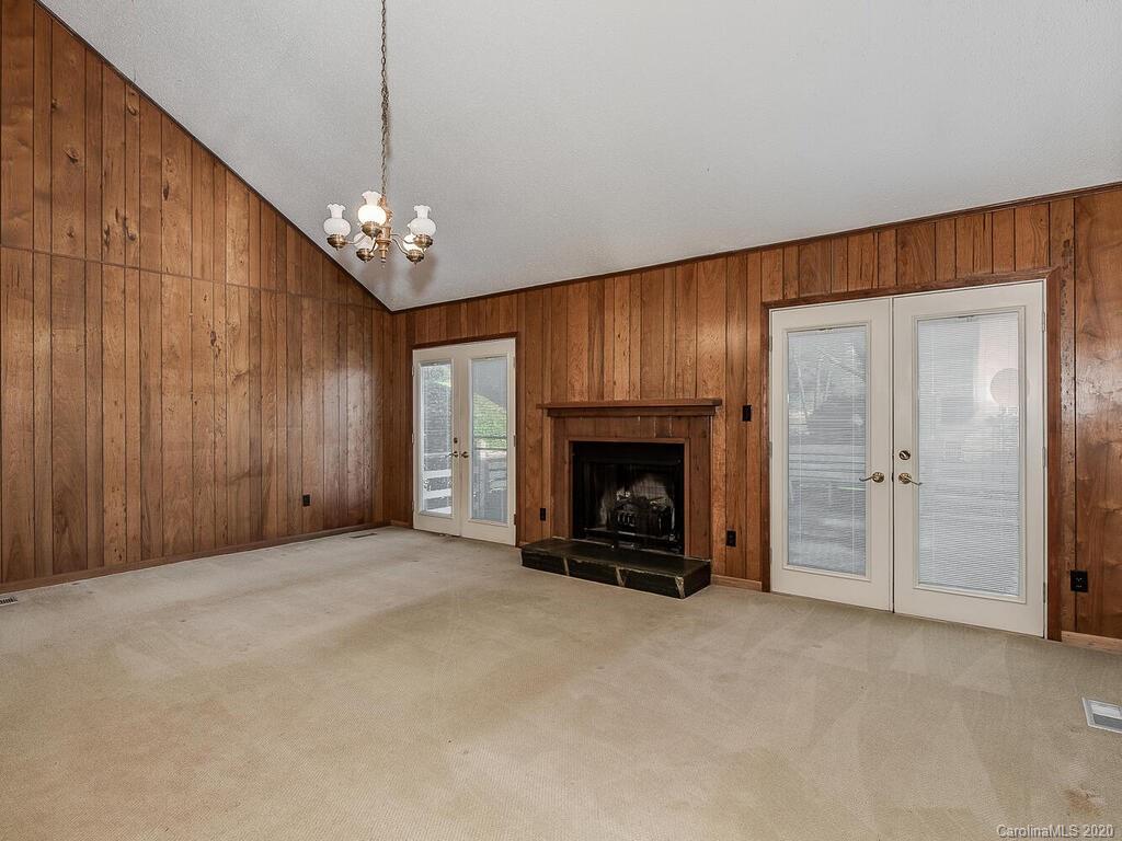 5012 Rounding Run Road Charlotte, NC 28277 - Photo 14 of 28 an empty room with windows fireplace and a kitchen view