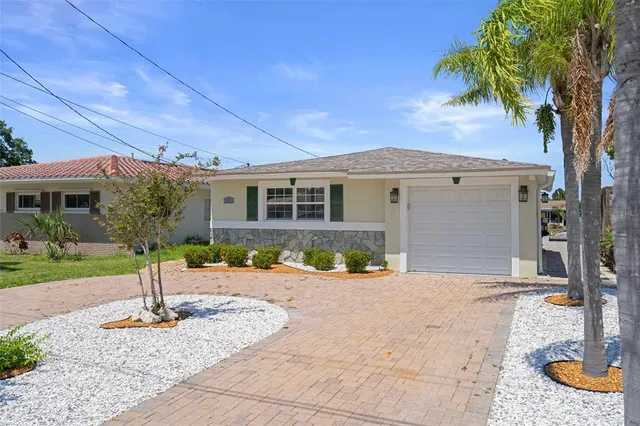 a front view of a house with a yard and potted plants