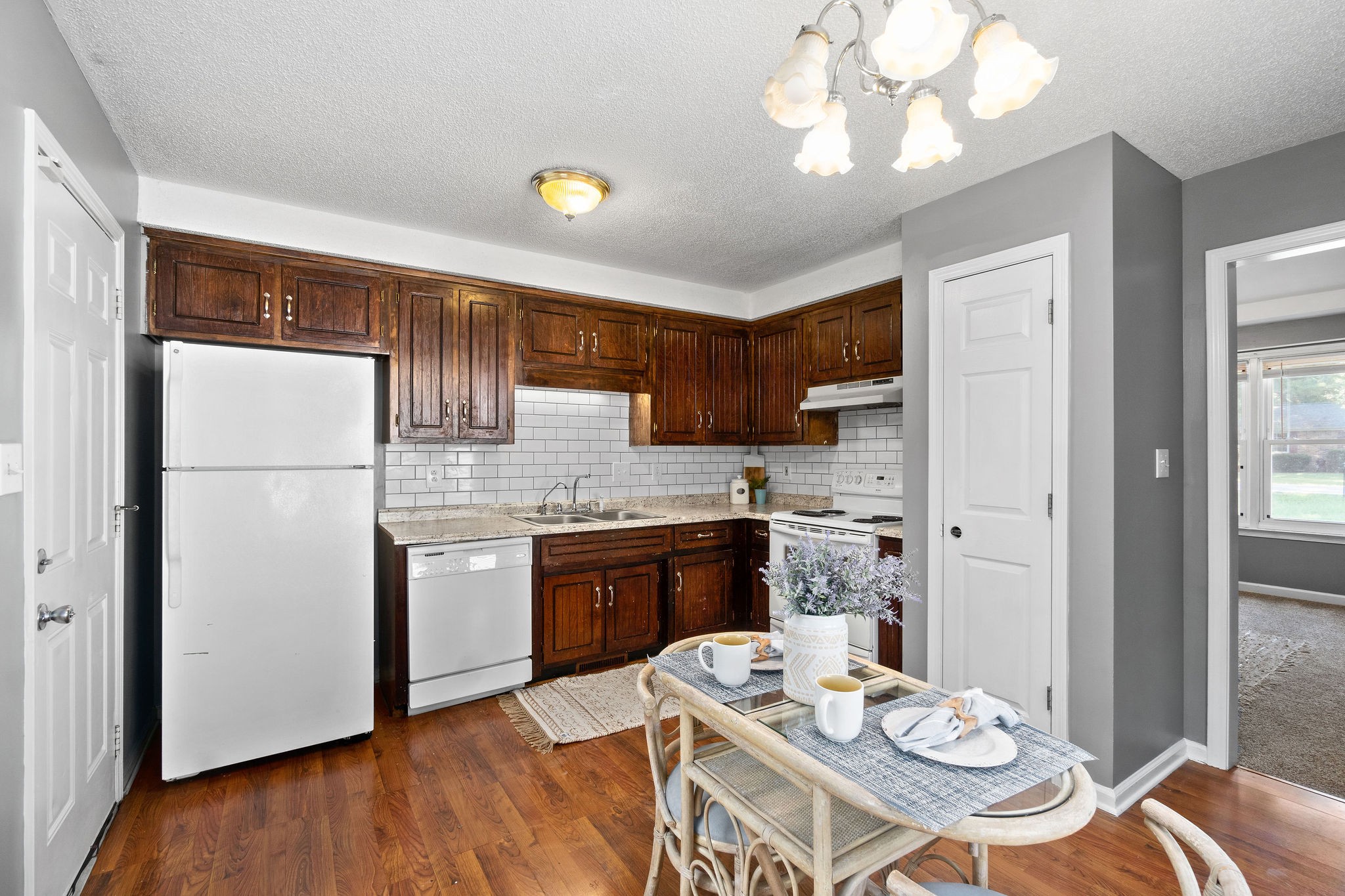 742 Needmore Road Clarksville, TN 37040 - Photo 11 of 35 a kitchen with stainless steel appliances granite countertop a refrigerator a sink dishwasher a stove a dining table and chairs with wooden floor