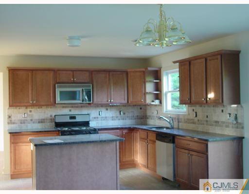 38 Burke Road Freehold, NJ 07728 - Photo 2 of 10 a kitchen with stainless steel appliances granite countertop a sink stove and cabinets