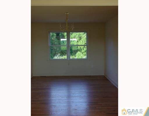 38 Burke Road Freehold, NJ 07728 - Photo 5 of 10 a view of an empty room with wooden floor and a window