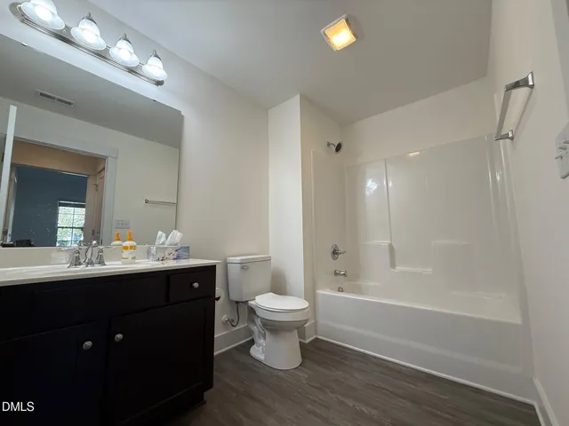 a front view of house with yard and trees in the background