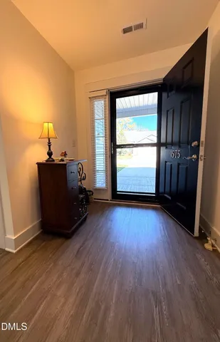 a kitchen with stainless steel appliances a stove top oven a sink a refrigerator white cabinets and wooden floor