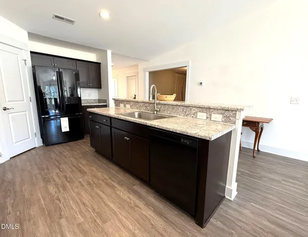 a living room with furniture a dining table wooden floor and a fireplace
