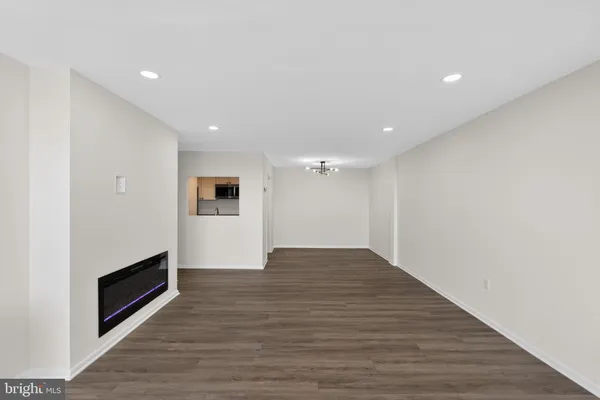 a view of empty room with wooden floor and fireplace