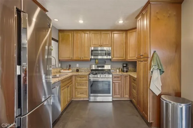 a kitchen with stainless steel appliances granite countertop a refrigerator and a stove top oven