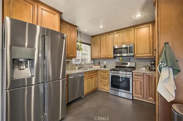 a kitchen with stainless steel appliances granite countertop a refrigerator stove microwave and sink