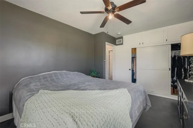 a bedroom with a bed and a ceiling fan
