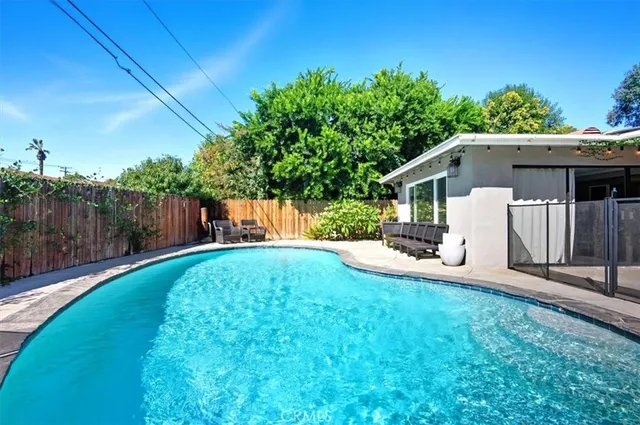 a view of a house with backyard and sitting area