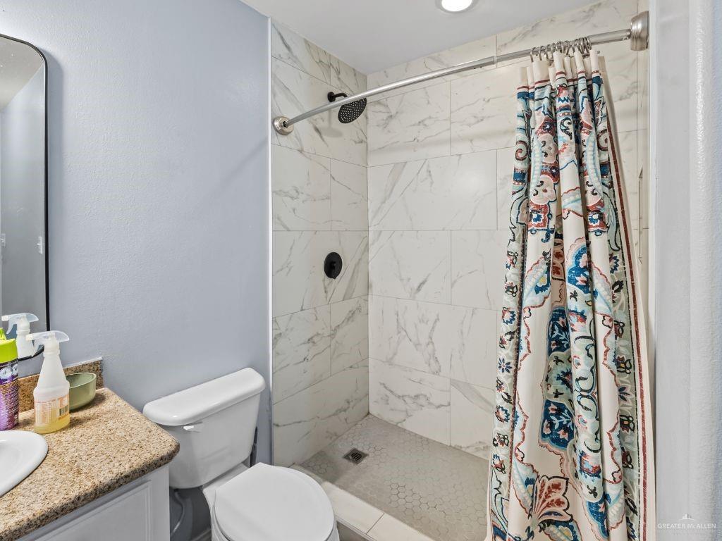 1012 Alpine Avenue Rio Grande City, TX 78582 - Photo 12 of 15 a bathroom with a granite countertop shower a toilet and a sink