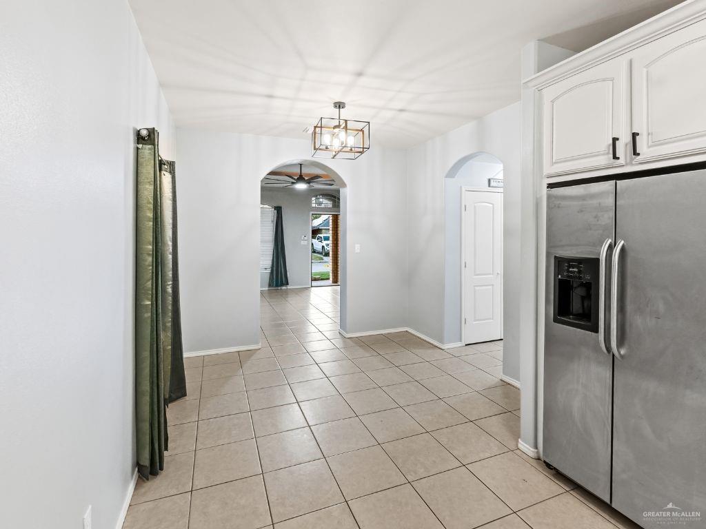 1012 Alpine Avenue Rio Grande City, TX 78582 - Photo 5 of 15 a view of a refrigerator in kitchen and an empty room in wooden floor
