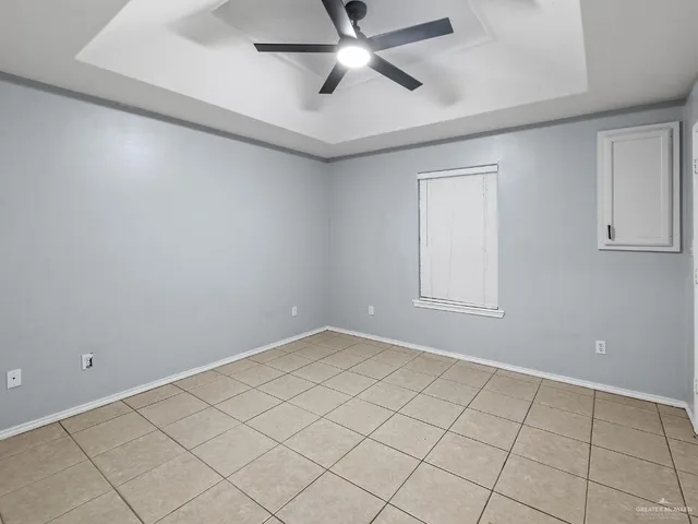 an empty room with windows and ceiling fan