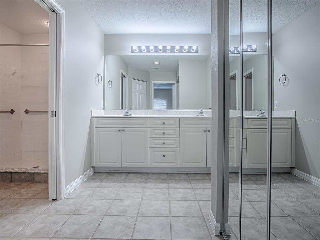 5318 Edgewater Way, Unit 10 Oxford, FL 34484 - Photo 13 of 18 a spacious bathroom with a mirror and a shower