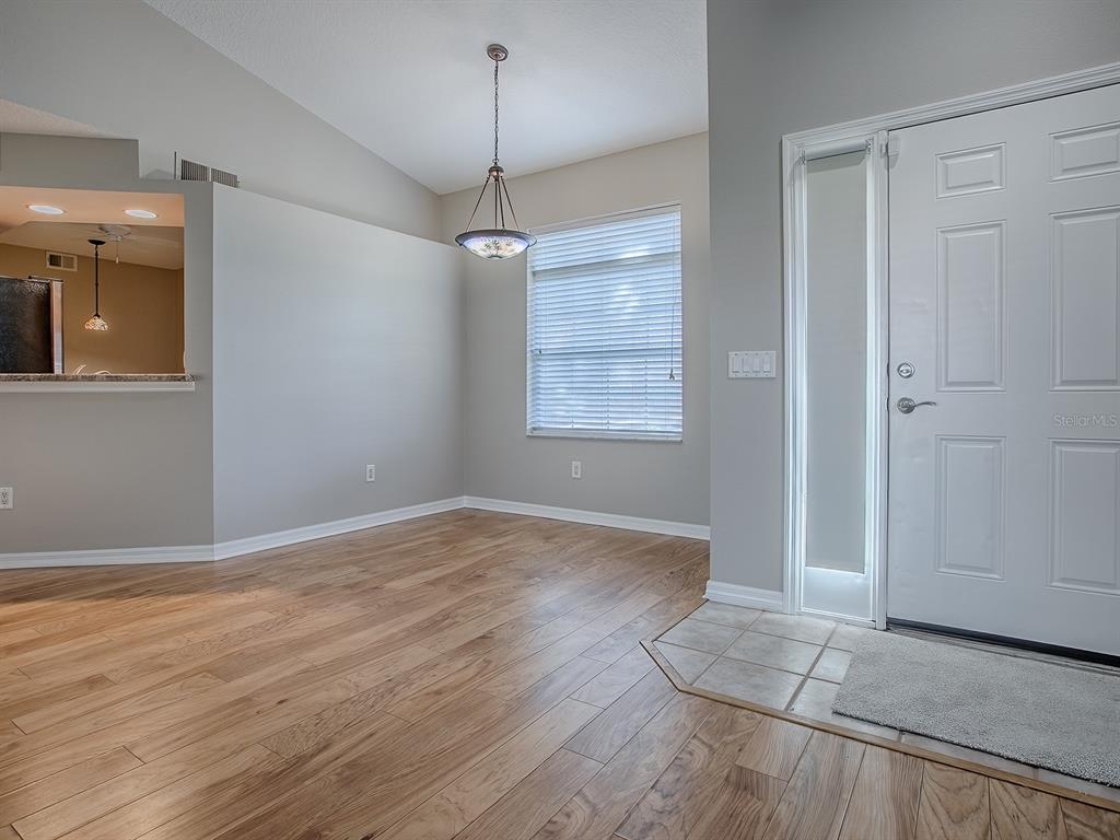 5318 Edgewater Way, Unit 10 Oxford, FL 34484 - Photo 3 of 18 an empty room with wooden floor cabinet and windows