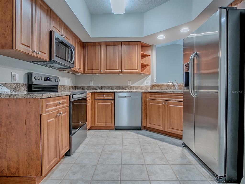 5318 Edgewater Way, Unit 10 Oxford, FL 34484 - Photo 7 of 18 a kitchen with stainless steel appliances granite countertop a stove top oven a sink dishwasher and a refrigerator