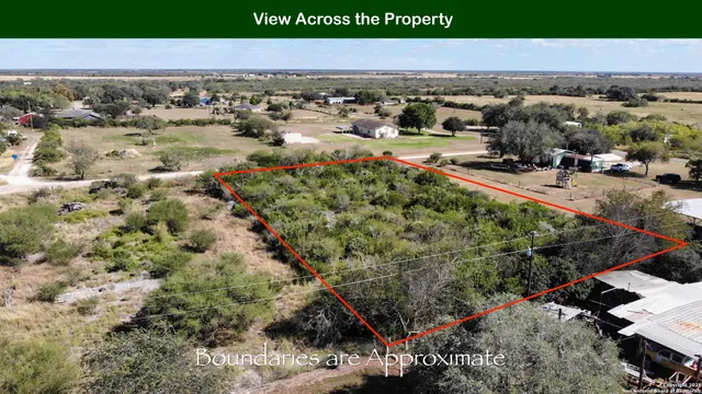 an aerial view of a houses with a yard and parking space