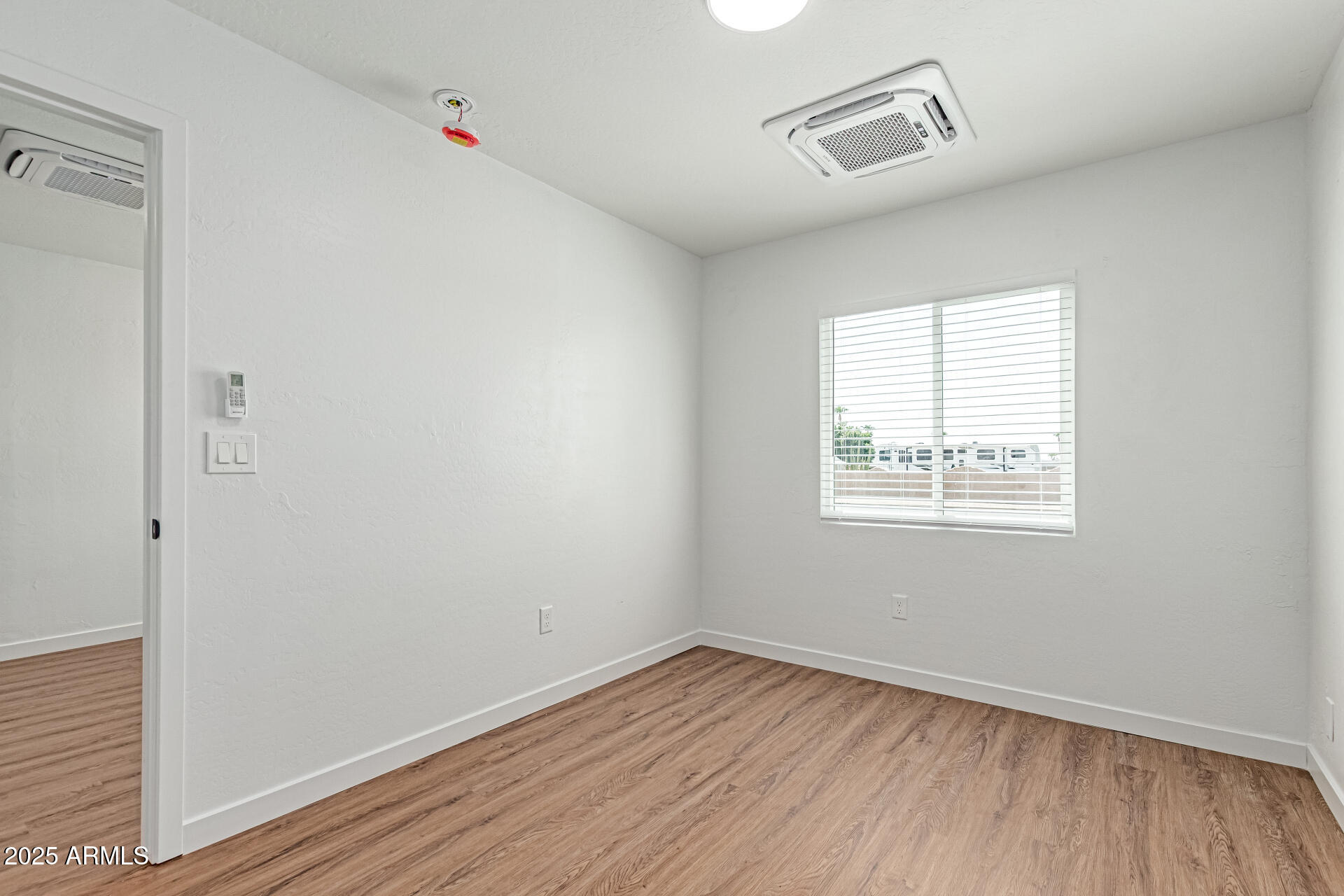 341 South Mountain Road, Unit 4 Apache Junction, AZ 85120 - Photo 12 of 18 an empty room with wooden floor and windows