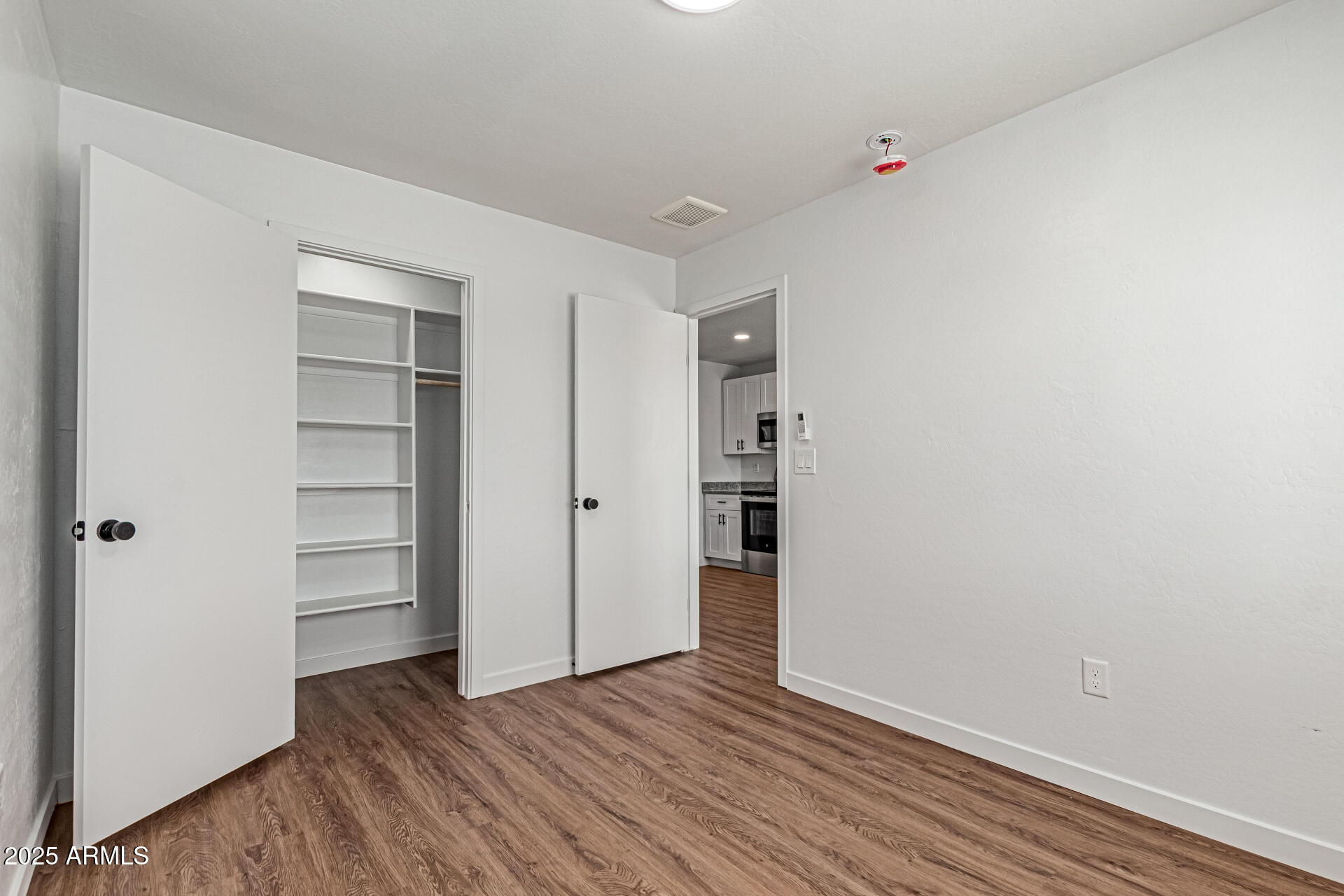 341 South Mountain Road, Unit 4 Apache Junction, AZ 85120 - Photo 13 of 18 a view of an empty room with closet and wooden floor