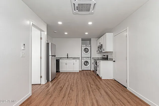 a kitchen with stainless steel appliances refrigerator wooden floor and cabinets