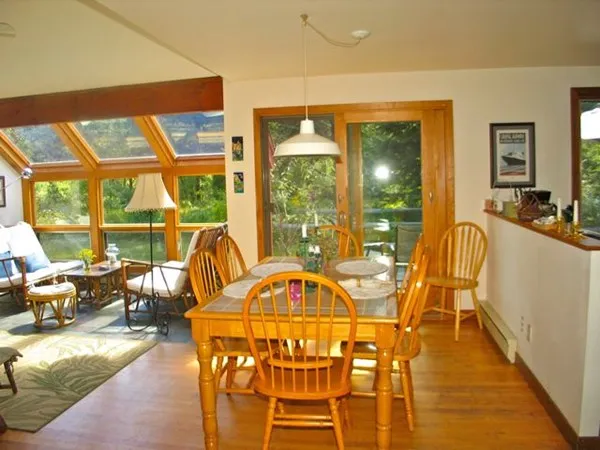 a view of a dining room with furniture large windows and wooden floor