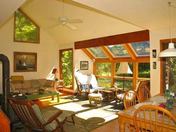 a view of a dining room with furniture one side kitchen view and a chandelier