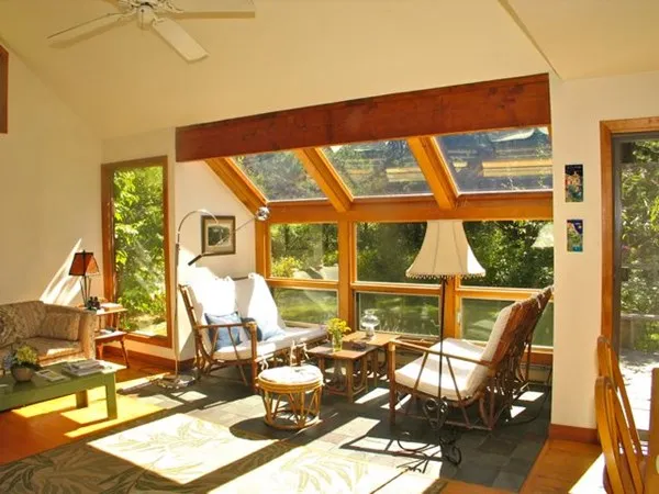 a living room with patio furniture and floor to ceiling windows