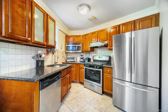 a kitchen with stainless steel appliances granite countertop a refrigerator stove microwave and sink