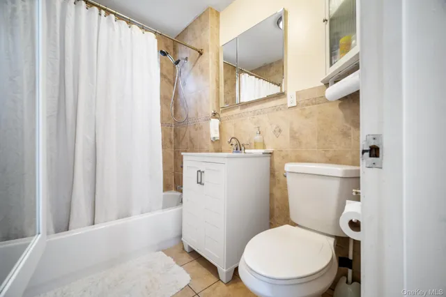 a white toilet sitting next to a shower curtain