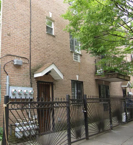 a front view of a house with glass windows and furniture