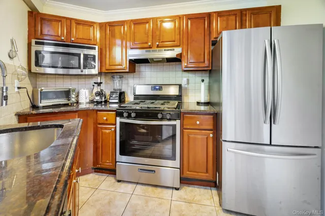 a kitchen with granite countertop a refrigerator stove and microwave