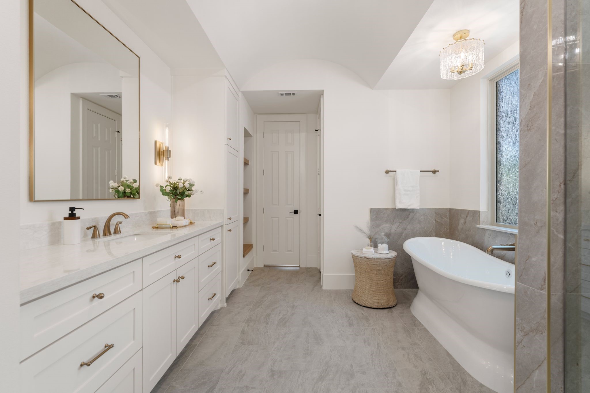 31 Hollymead Drive Spring, TX 77381 - Photo 23 of 50 This elegant bathroom features a spacious double vanity with modern fixtures, a freestanding bathtub, and a large mirror. The neutral color palette and natural light create a serene, spa-like atmosphere.