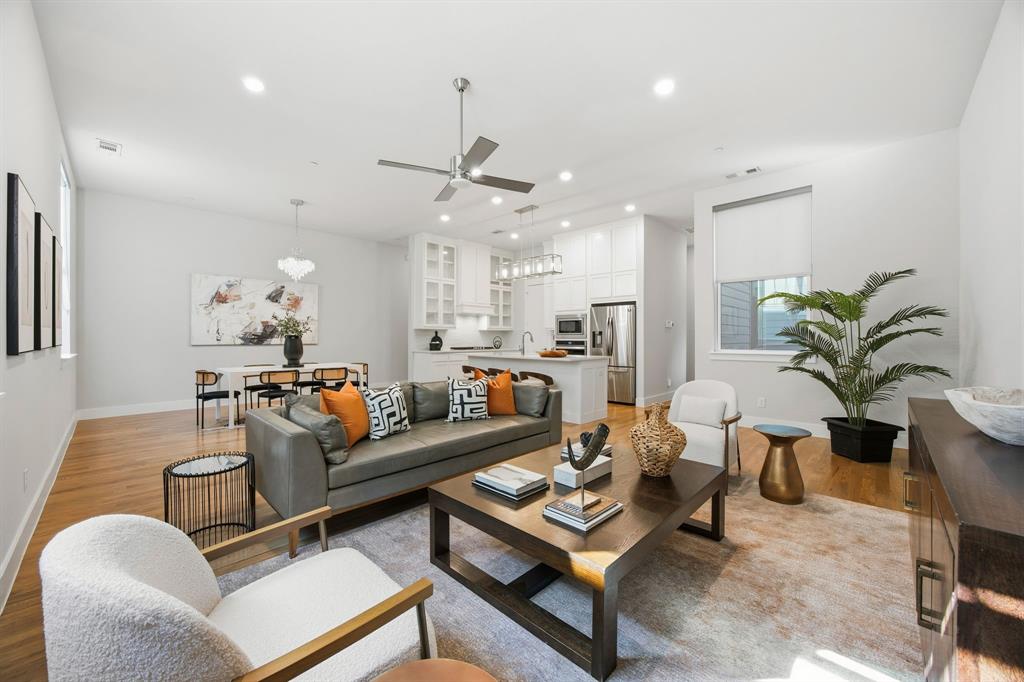 a living room with furniture kitchen view and a chandelier