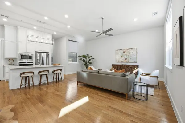 a living room with furniture a table and wooden floor