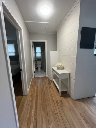 a walk in closet with wooden floor and cabinets
