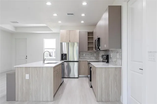 a kitchen with stainless steel appliances granite countertop a sink and refrigerator