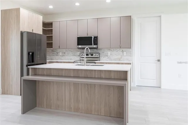 a kitchen with kitchen island cabinets and refrigerator