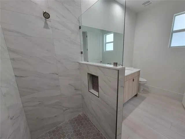 a bathroom with a sink a toilet and mirror