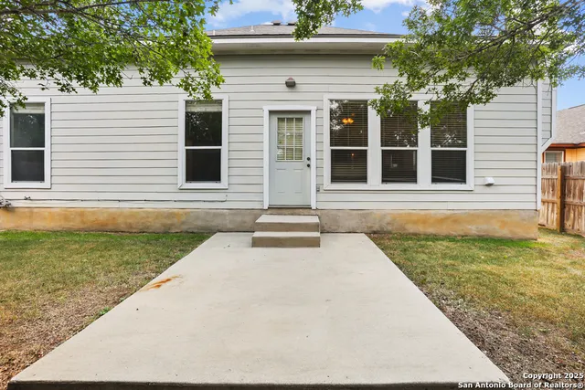 a view of a house with backyard and a tree