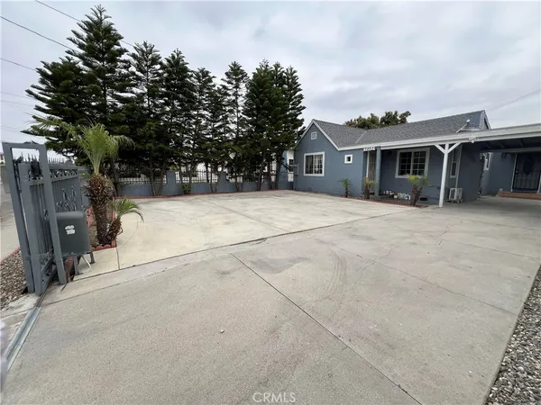 a front view of house with yard and trees in the background
