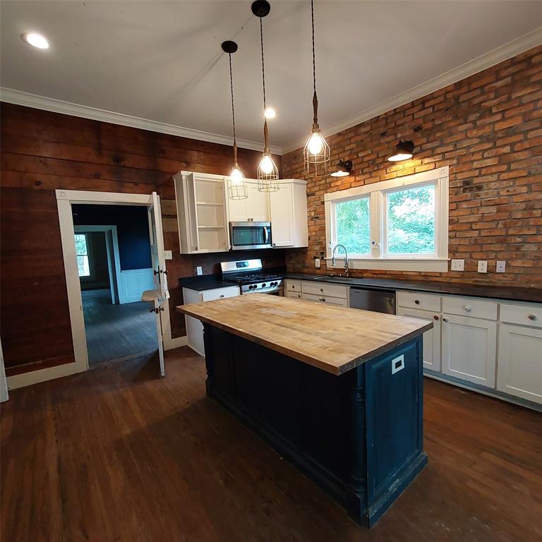 601 Holbrook Street Mount Vernon, TX 75457 - Photo 13 of 35 a kitchen with stainless steel appliances granite countertop wooden cabinets a stove a sink and a wooden floors