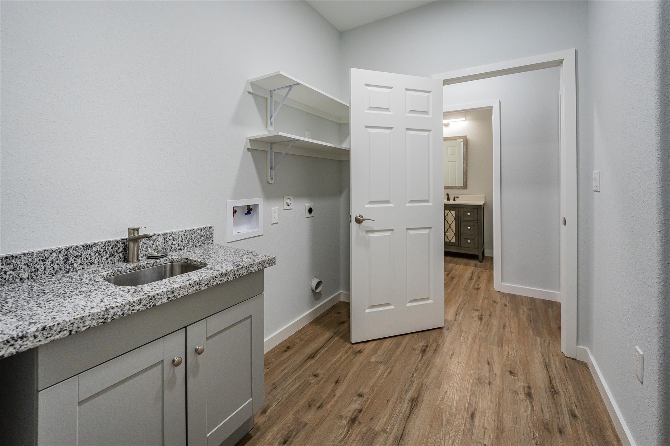 24411 Oakaland Hls Road Point Blank, TX 77364 - Photo 33 of 40 a kitchen with a sink a refrigerator and wooden floor
